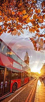 Big Ben against colorful sunset with red bus during autumn in London, England
