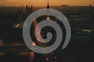 Big Ben Clock Tower in London on sunset. Westminster Bridge in London city aerial view.