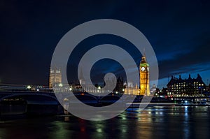 Big Ben and the Houses of Parliament at night from across the river Thames and Westminster bridge southbank in London, England, UK