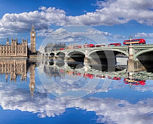 Big Ben and Houses of Parliament with red buses on the bridge in London, England, UK