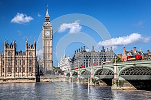 Big Ben and Houses of Parliament with red buses on the bridge in London, England, UK