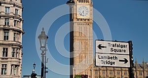 Big Ben, Houses of Parliament and road sign to Trafalgar Square and Lambeth Bridge, London, England