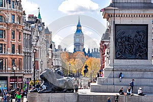 Big Ben tower and Lion statue at Nelson`s column on Trafalgar square, London, UK