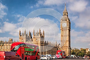 Big Ben with typical red buses on the bridge in London, England, UK