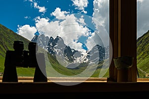 Binoculars lying on sill overlooking mountain.
