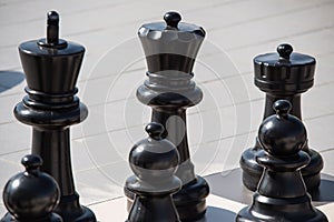 Big black chess made of plastic. Selective focus macro shot with shallow DOF
