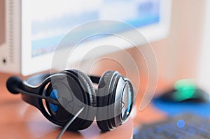 Big black headphones lie on the wooden desktop of the sound designer