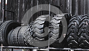 Big black huge big truck, tractor or bulldozer loader tires wheel close-up on stand, shop selling tyres for farming and big vehicl