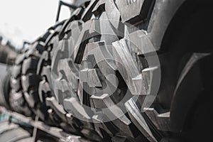 Big black huge big truck, tractor or bulldozer loader tires wheel close-up on stand, shop selling tyres for farming and big vehicl