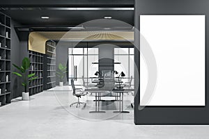 Big blank white poster with space for your logo or text on black wall in dark interior office with black walls, workspaces with