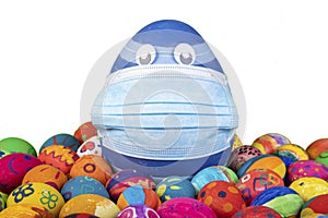 Big blue egg with face mask between painted easter eggs before white background