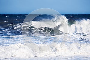 Big blue ocean wave crashing near the coast