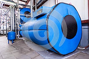 Big blue reservoirs in factory boiler room