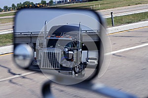 A big blue truck in the vehicle mirror