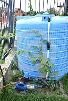 Big blue water plastic tank for garden or landscape irrigation with pipe