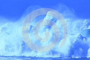 Big blue ocean wave with sea spray tossed up