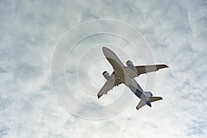 Plane flies  of blue sky and clouds
