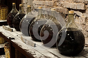 Big bottle in a cellar with aged alcohol