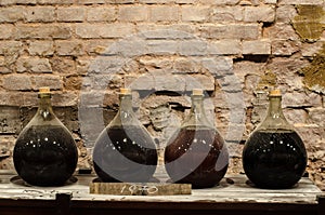 Big bottle in a cellar with aged alcohol