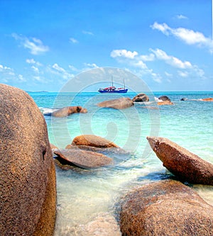 Big boulders at the tropical coastline with turqiouse seawater