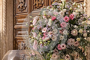 Big bouquets of colorful flowers. Luxury wedding floral decorations at the entrance of Ostuni church.