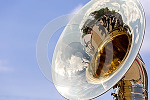 Big brass tuba with reflections against blue sky