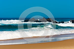 Big breaking Ocean wave on a sandy beach