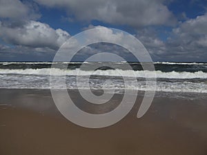 Big breaking Ocean wave on a sandy beach on the baltic sea in Poland