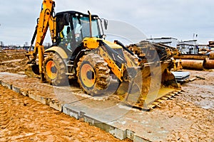 Big bright yellow powerful industrial heavy excavator tractor, bulldozer, specialized construction equipment for road repair