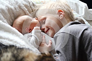 Big Brother Hugging Newborn Baby with Love