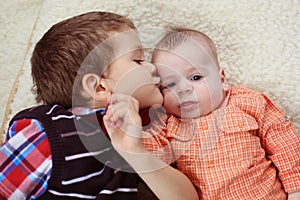 Big brother kissing the baby