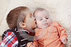 Big brother kissing the baby