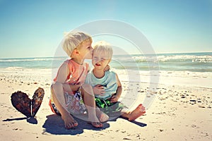 Big Brother Kissing Young Child on Beach