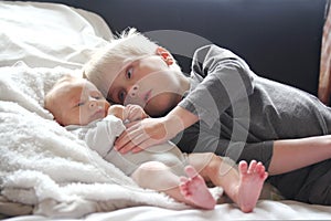 Big Brother Lovingly Playing with Newborn Baby Sister