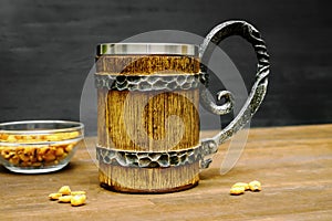 Big brown mug of beer,ale and crispy snacks, pretzels, corn, nuts in bowl on wooden table, background close up. Alcohol cocktail,