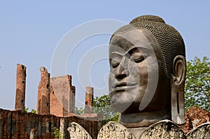 Big Buddha head with red old brick pole on background , blue sky