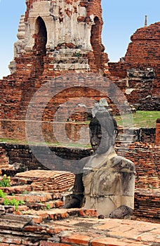 Big Buddha sculpture made of stone on the brick ruins of Wat Phra Sri Sanphet. Ayutthaya, Thailand.