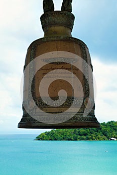 A big buddhist bell in front of a tropical sea paysage