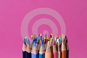 Big bunch of colorful pencils on pink background. Education, back to school concept with copy space