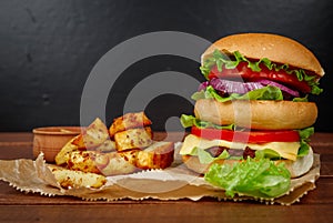 Big burger with fries on dark