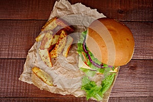 Big burger with fries on wooden