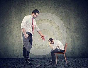 Big businessman giving a hand supporting a depressed desperate guy