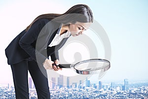Big businesswoman with magnifier
