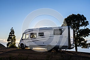 Big camper motorhome parked in off road nature space to enjoy total freedom. Off grid lifestyle vanlife. Travel with camping car