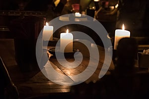 Big candle in a plate on a wooden table
