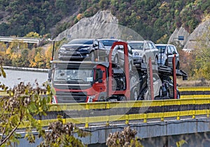 An automotive car carrier truck driving down the highway with a full load of new vehicles.