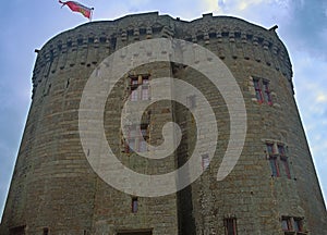 Big central stone tower with flag on top at Dinan fortress, France