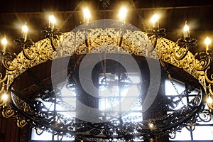 Big chandelier on the ceiling in Russian Orthodox Church with crucifix and electric lamps
