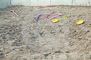 Big child`s sandpit with shovels and rakes