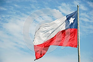 Big chilena flag waving in front on blue sky with copy space. photo